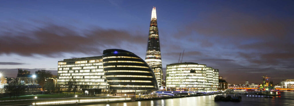 London skyline at dusk with illuminated modern buildings and river