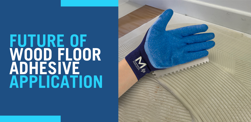 Worker applying wood floor adhesive with blue gloved hand