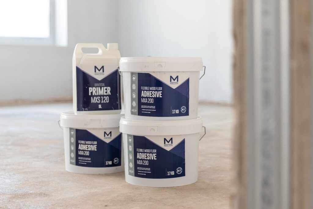 In the far left of the image you can make out the corner of a window and in the middle of the empty, recently plastered room sit 3 Marldon MXA200 adheive tubs and 1 bottle of MXS120 universal subfloor primer.