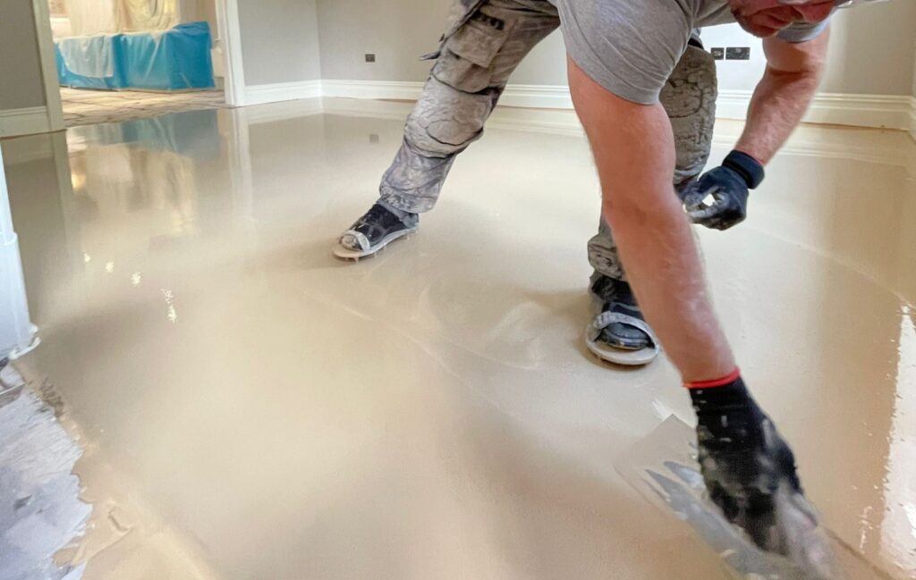 Workers applying epoxy resin coating to residential floor